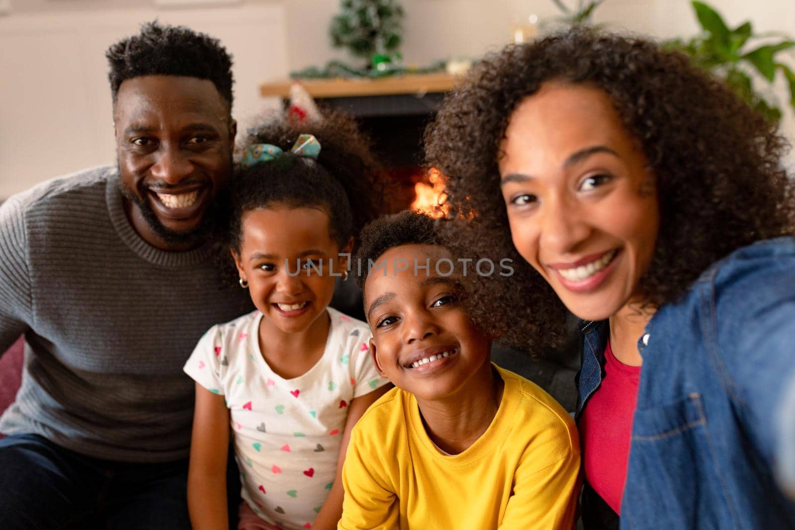 Happy african american family sitting on sofa, taking selfie by Wavebreakmedia