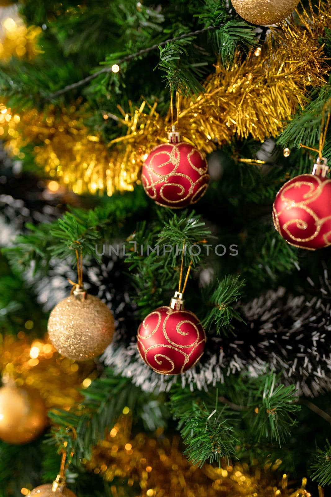 Baubles, chains and other decorations hanging on christmas tree by Wavebreakmedia