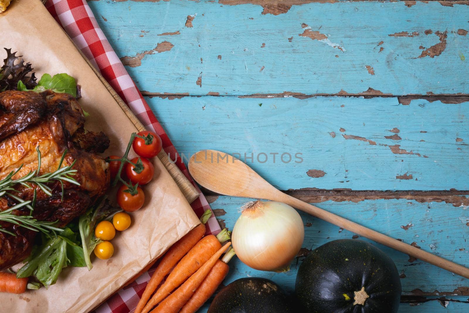 Cooked chicken and multiple food ingredients with copy space on blue wooden surface. food and restaurant concept