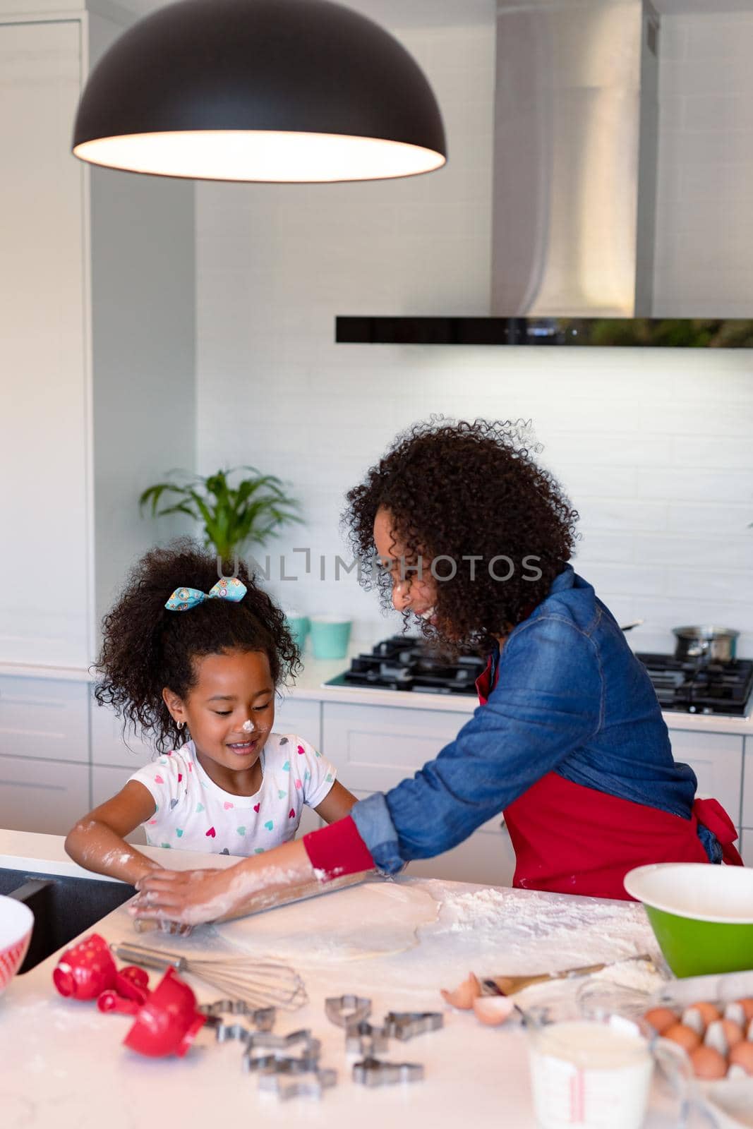 Happy african american mother and daughter baking together in kitchen by Wavebreakmedia