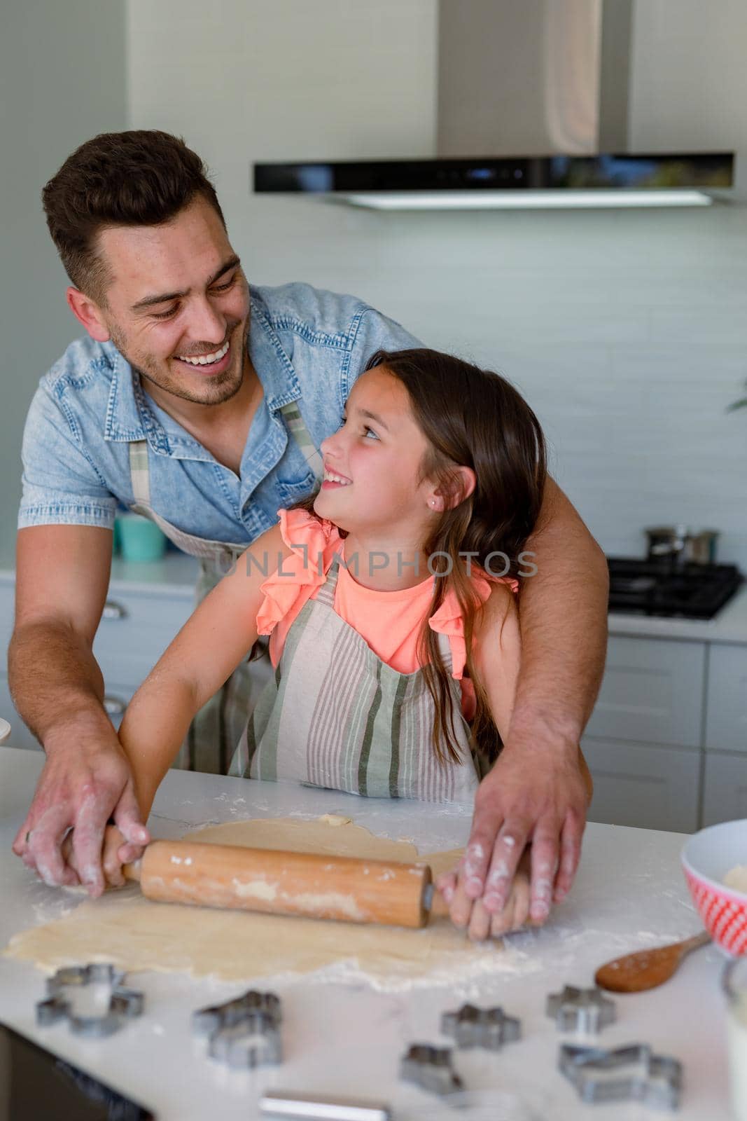 Happy caucasian father and daughter baking together, making cookies in kitchen. family time, having fun together at home.