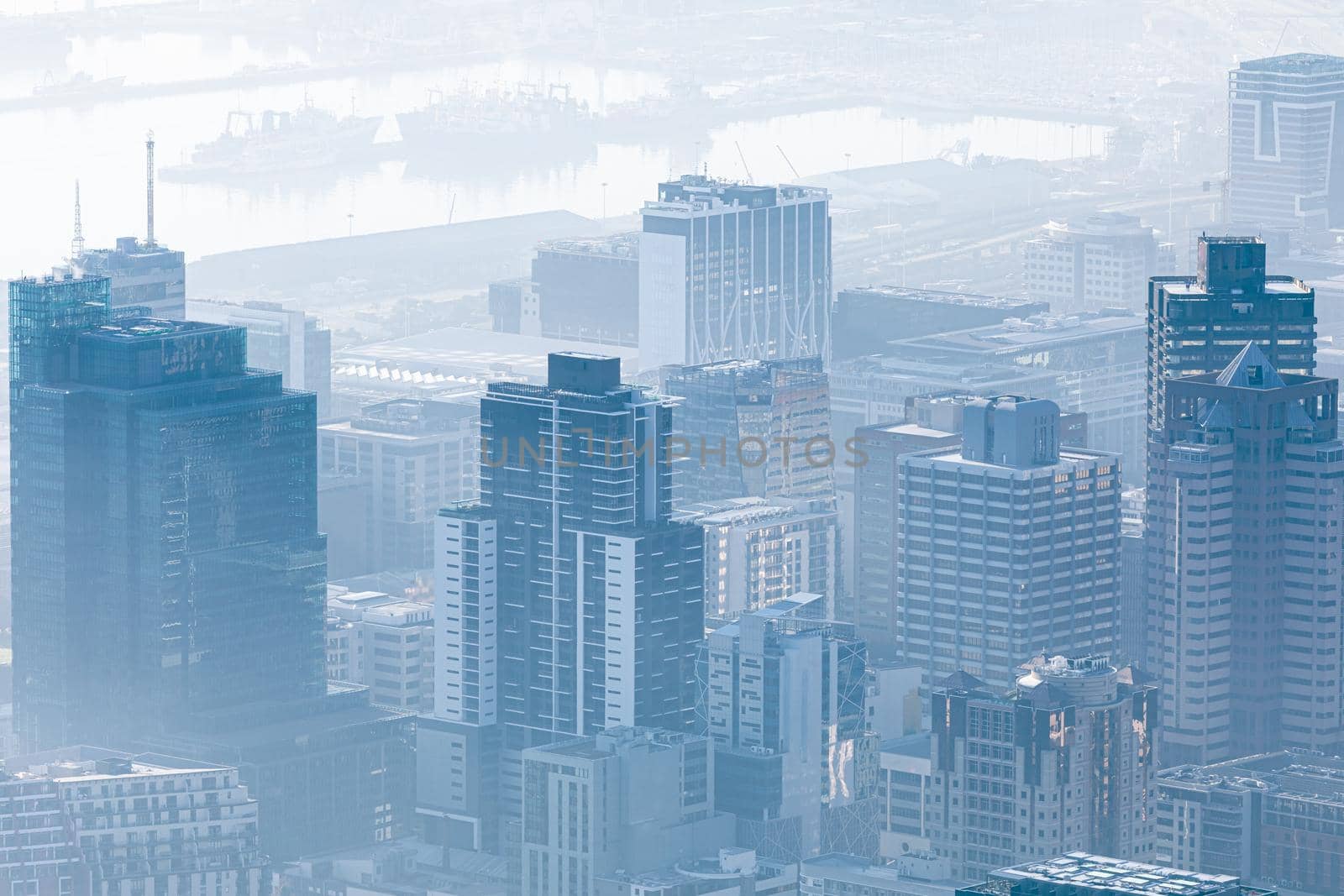 General view of cityscape with multiple modern buildings and cranes in the foggy morning. skyline and urban architecture.