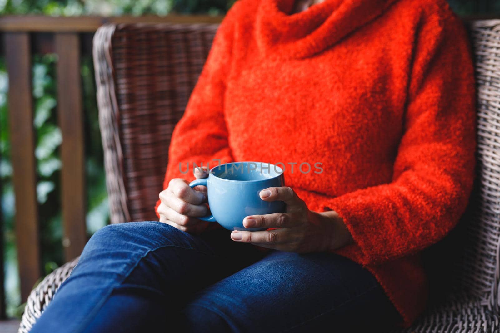 Midsection of senior caucasian woman sitting on chair, holding cup in garden by Wavebreakmedia