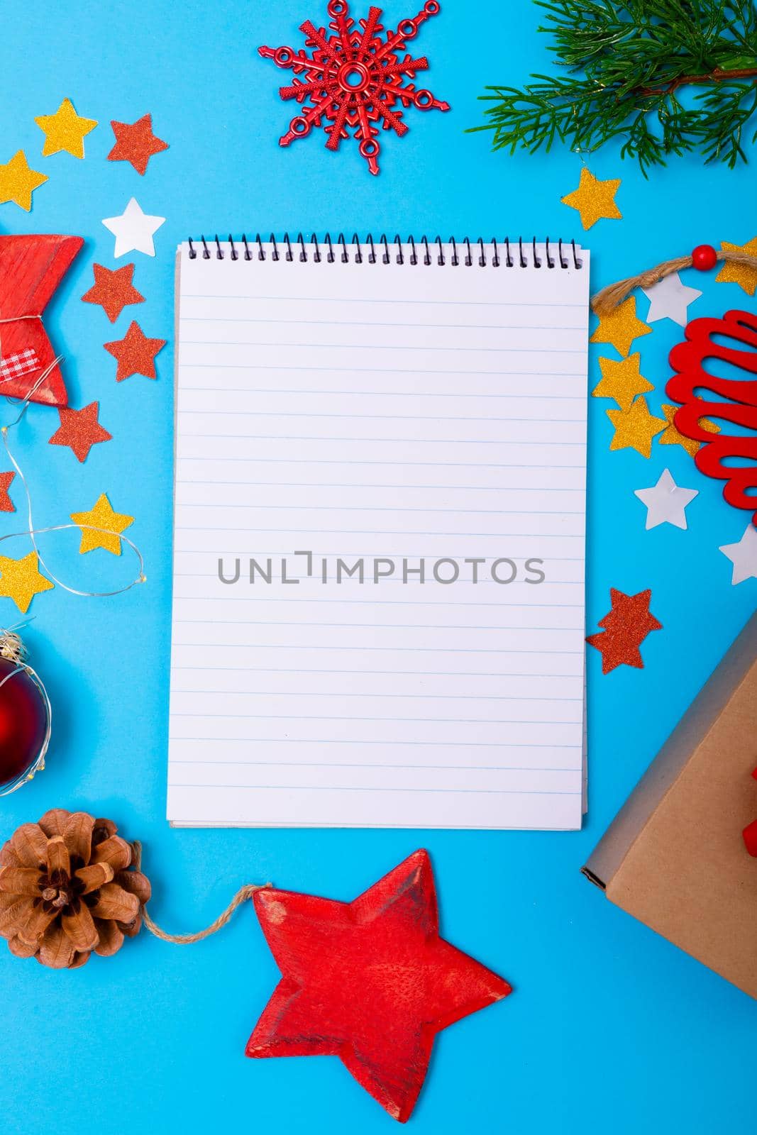 Composition of notebook with copy space and christmas decorations on blue background. christmas, tradition and celebration concept.