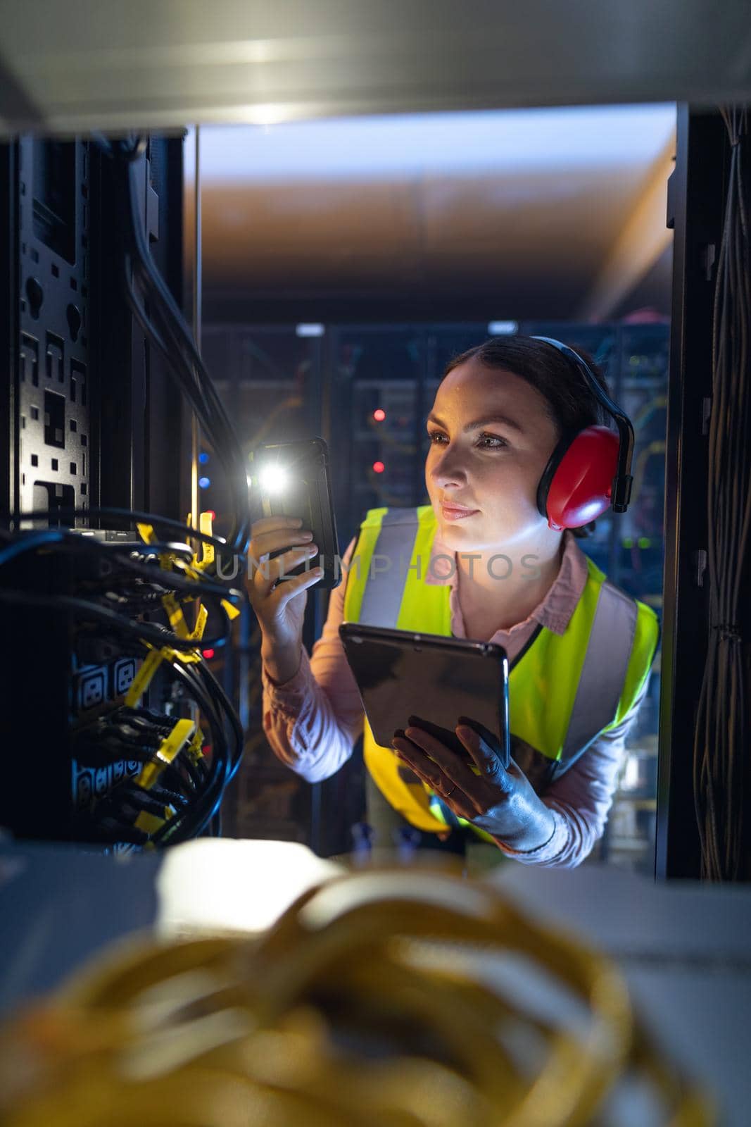 Caucasian female engineer using smartphone flash while inspecting the server in computer server room by Wavebreakmedia