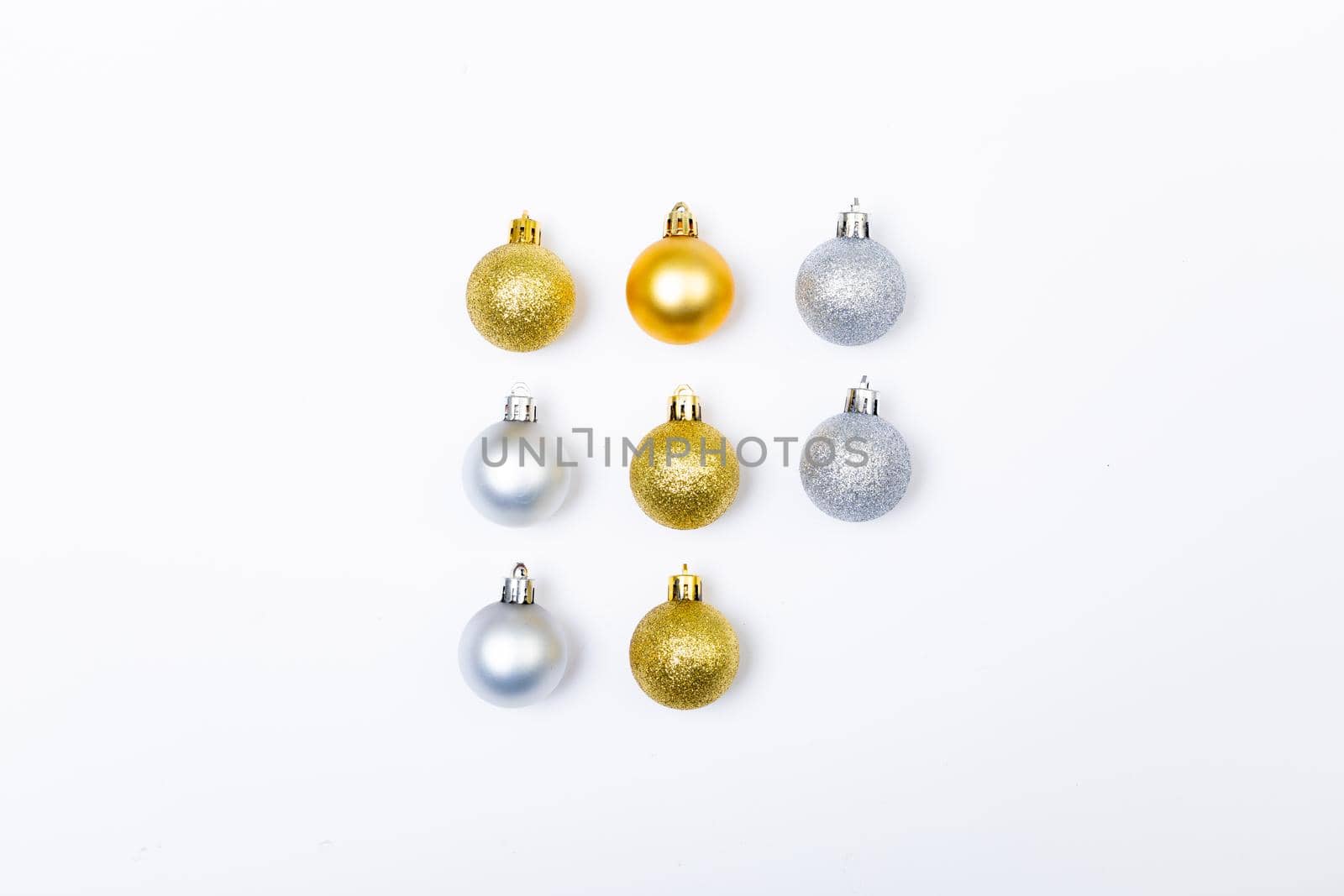 Composition of rows of gold and silver baubles on white background. christmas, tradition and celebration concept.