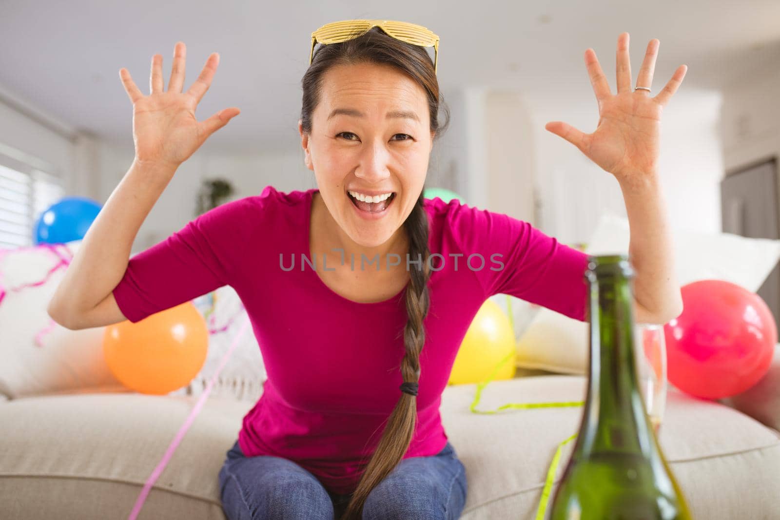 Happy asian woman raising hands making new year's eve laptop video call by Wavebreakmedia