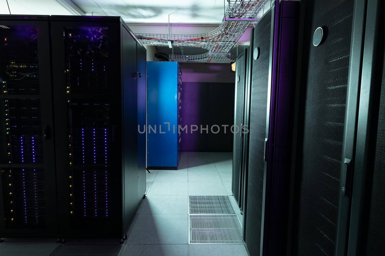 Data center with multiple rows of fully operational server racks by Wavebreakmedia