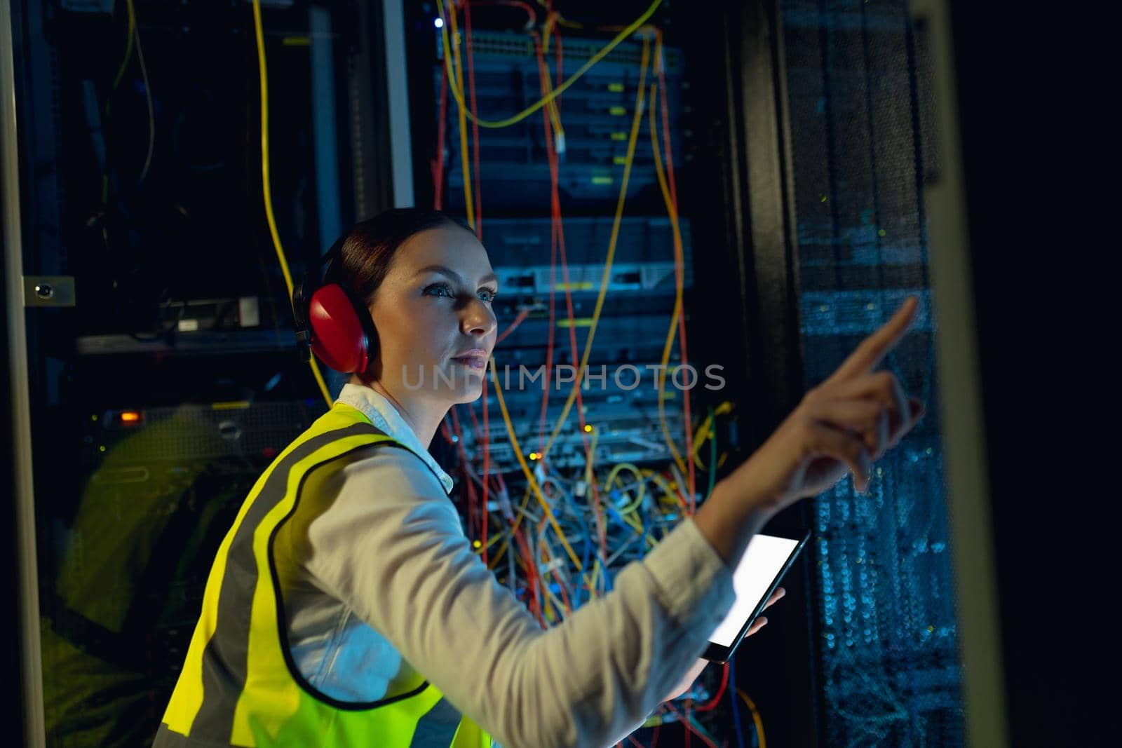 Caucasian female engineer using digital tablet while inspecting in computer server room by Wavebreakmedia