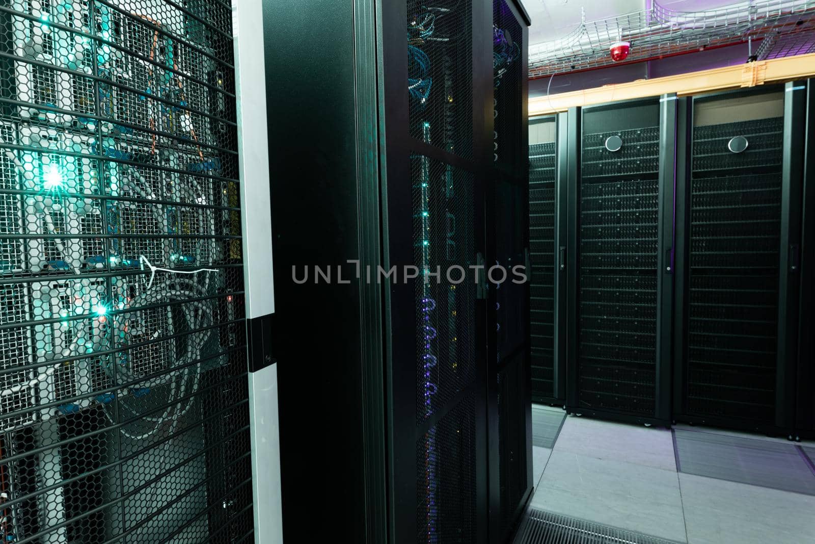 Data center with multiple rows of fully operational server racks. modern cloud computing technology concept.