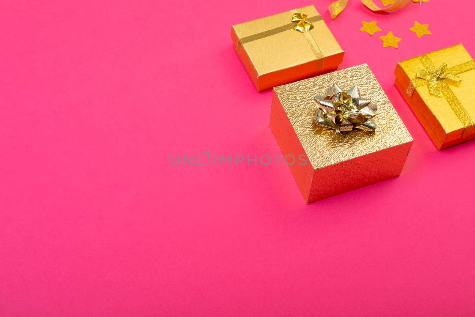 Composition of christmas decorations with presents and copy space on pink background. christmas, tradition and celebration concept.