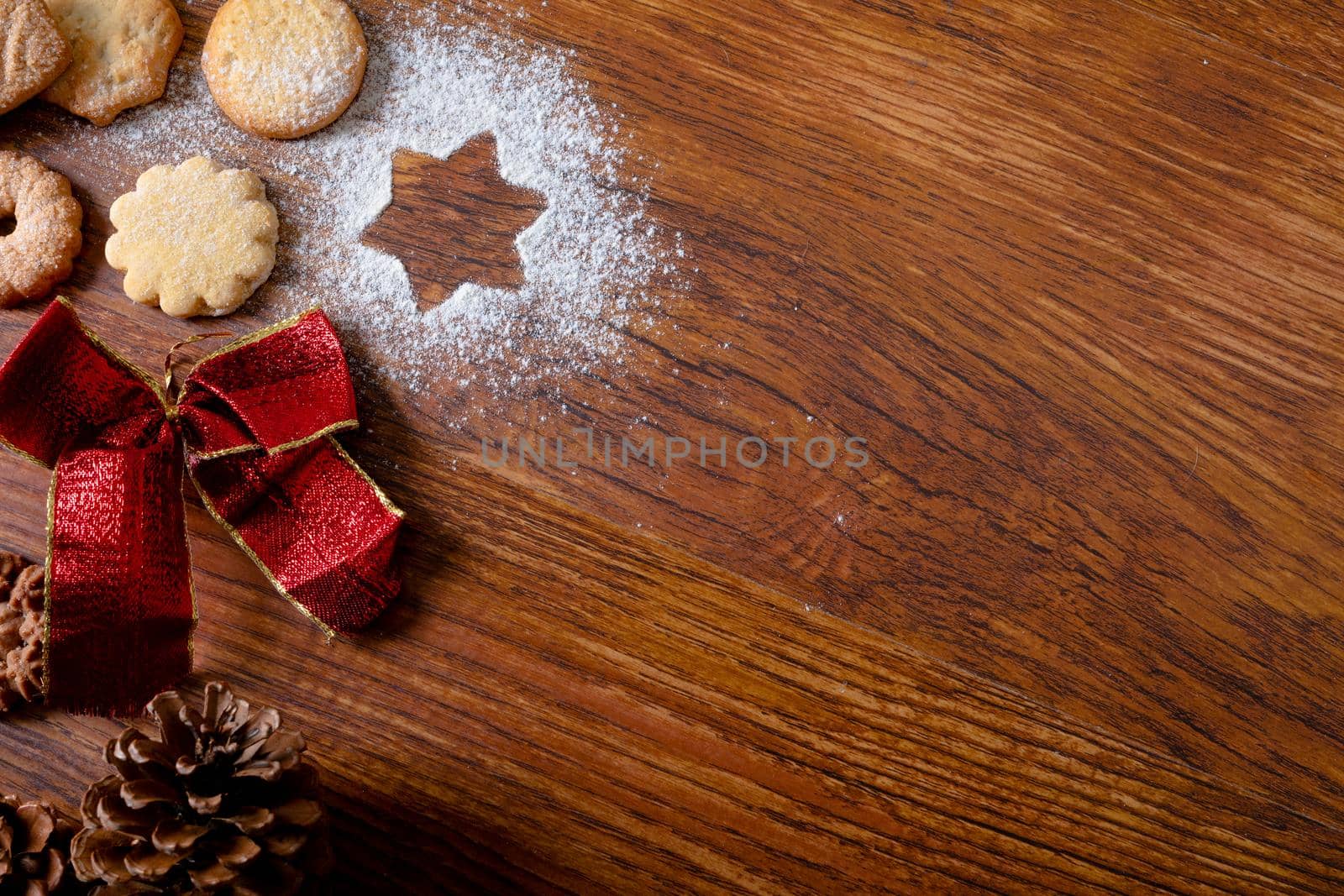 Composition of christmas decorations with christmas cookies and copy space on wooden background. christmas, tradition and celebration concept.