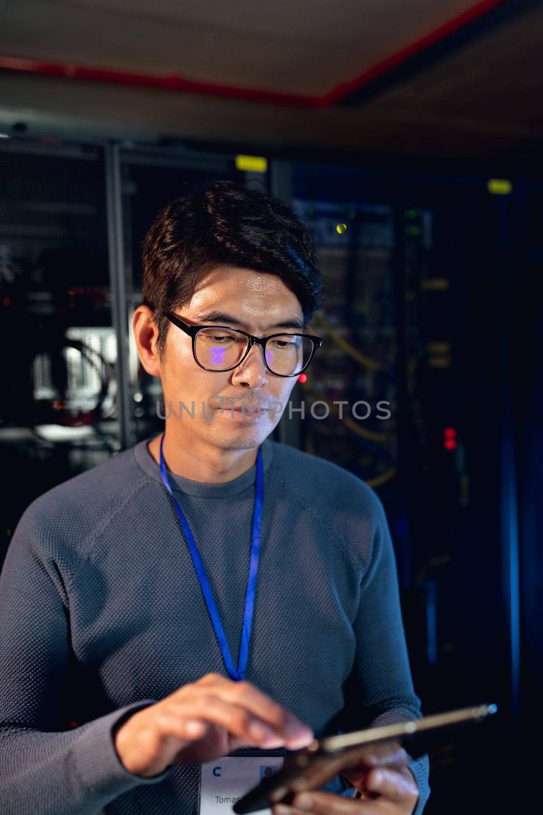 Asian male engineer using digital tablet in computer server room by Wavebreakmedia