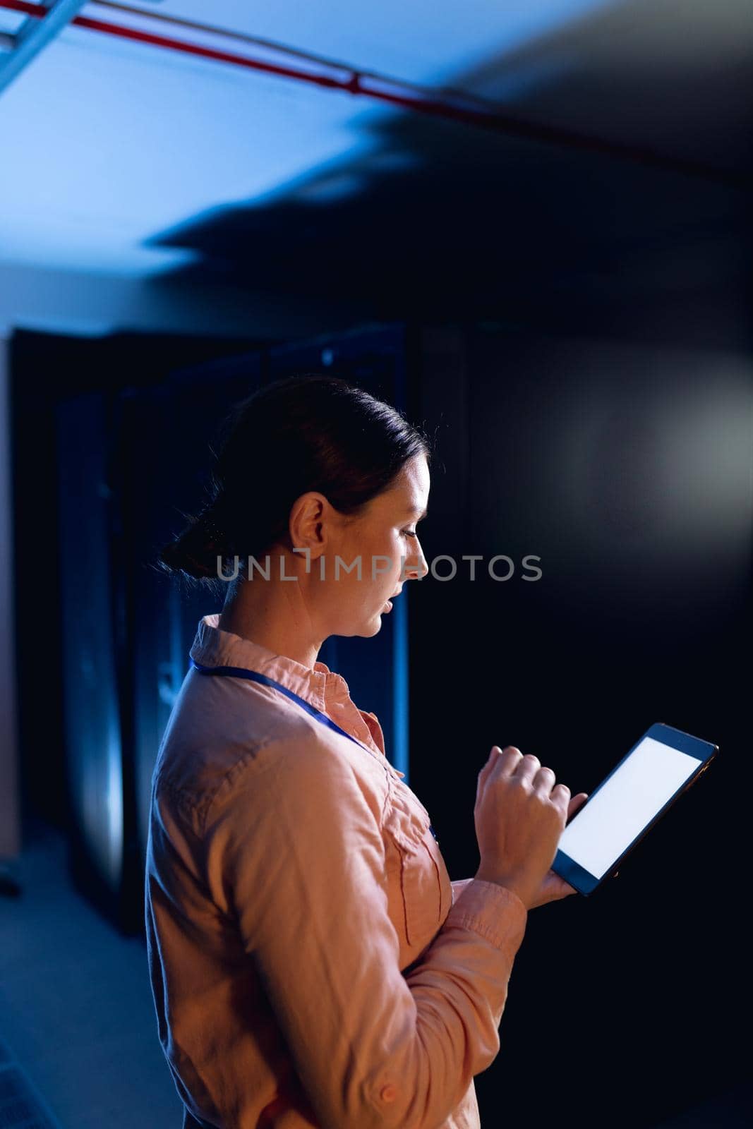 Caucasian female engineer using digital tablet in computer server room by Wavebreakmedia