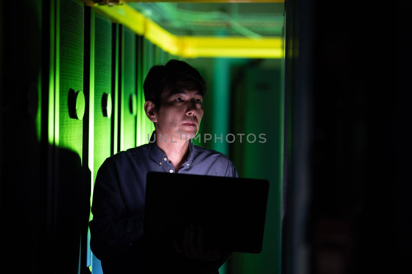 Asian male engineer using laptop while inspecting in computer server room by Wavebreakmedia