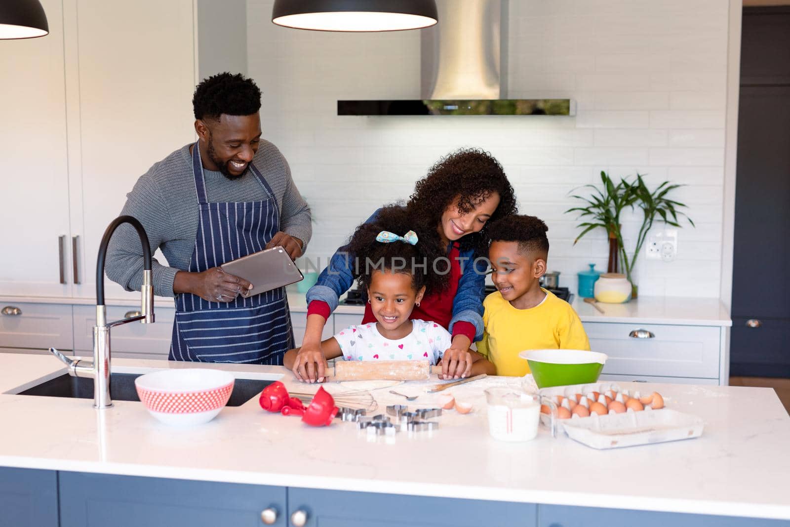 Happy african american family baking together in kitchen. family time, having fun together at home.