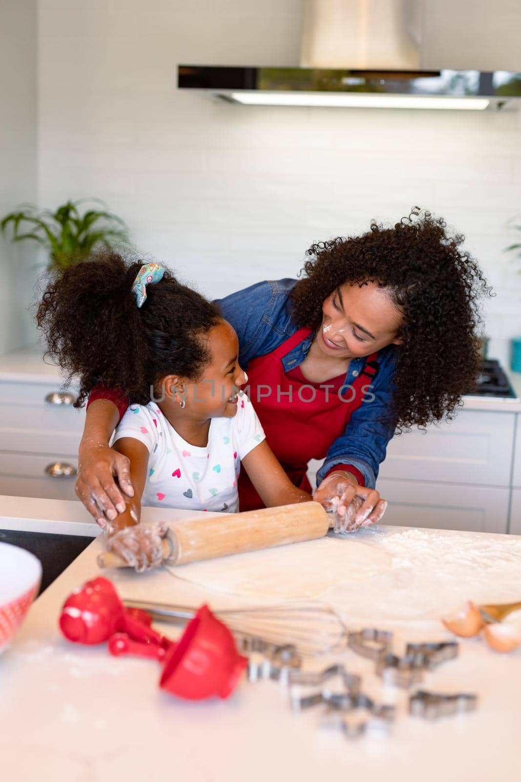 Happy african american mother and daughter baking together in kitchen by Wavebreakmedia