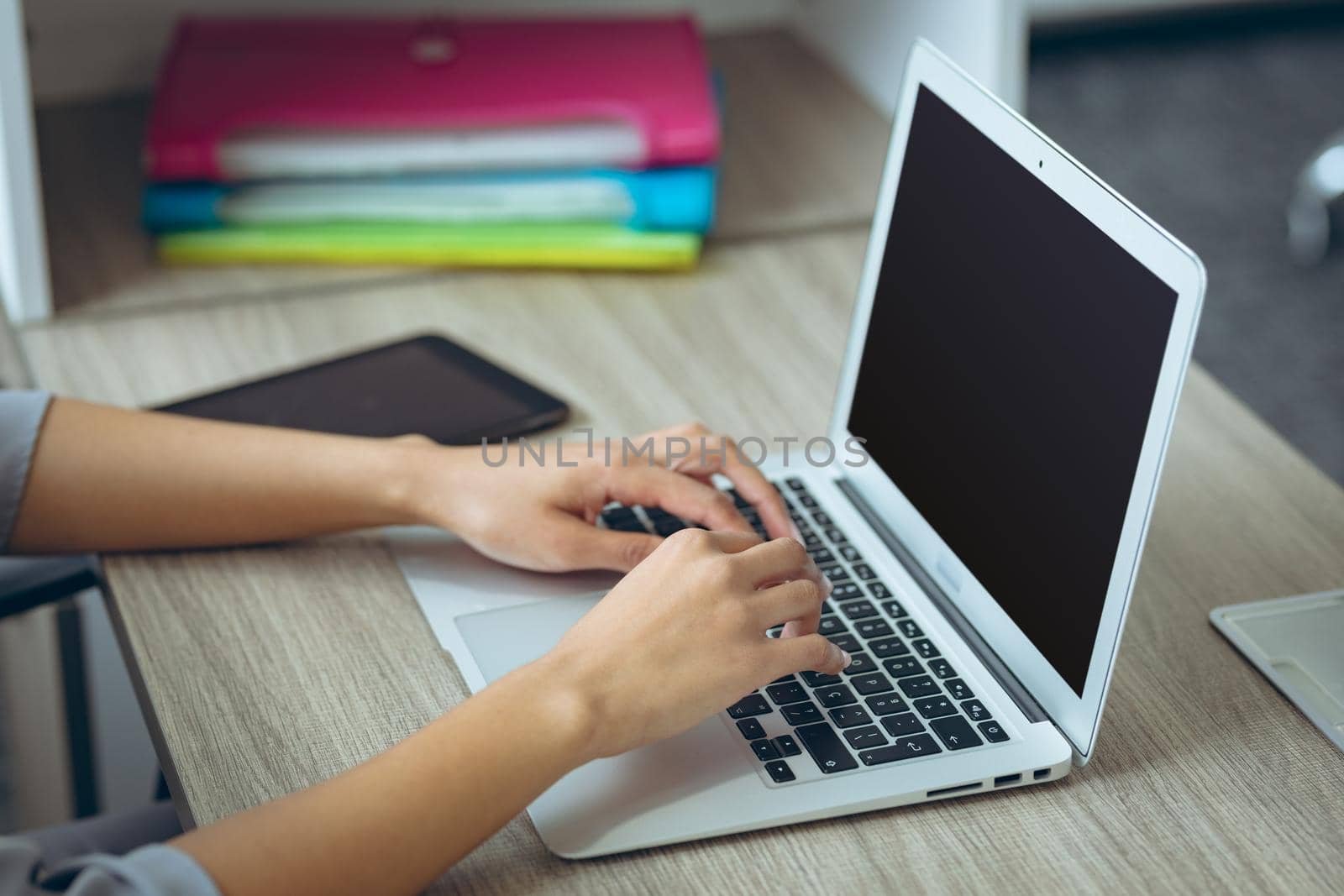 Mixed race businesswoman sitting at desk using laptop having video call by Wavebreakmedia