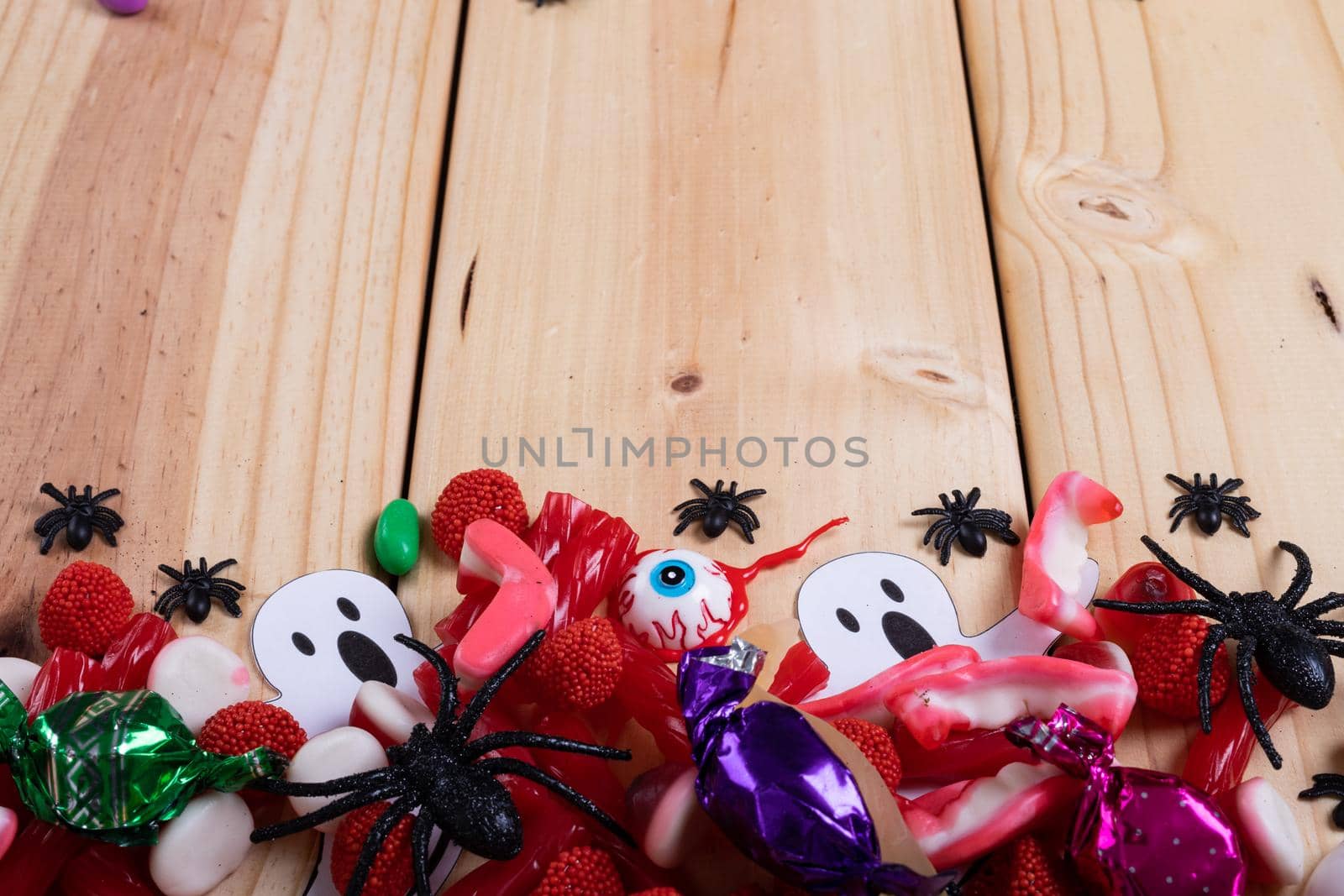 Multiple halloween toys and candies with copy space on wooden surface. halloween festivity and celebration concept