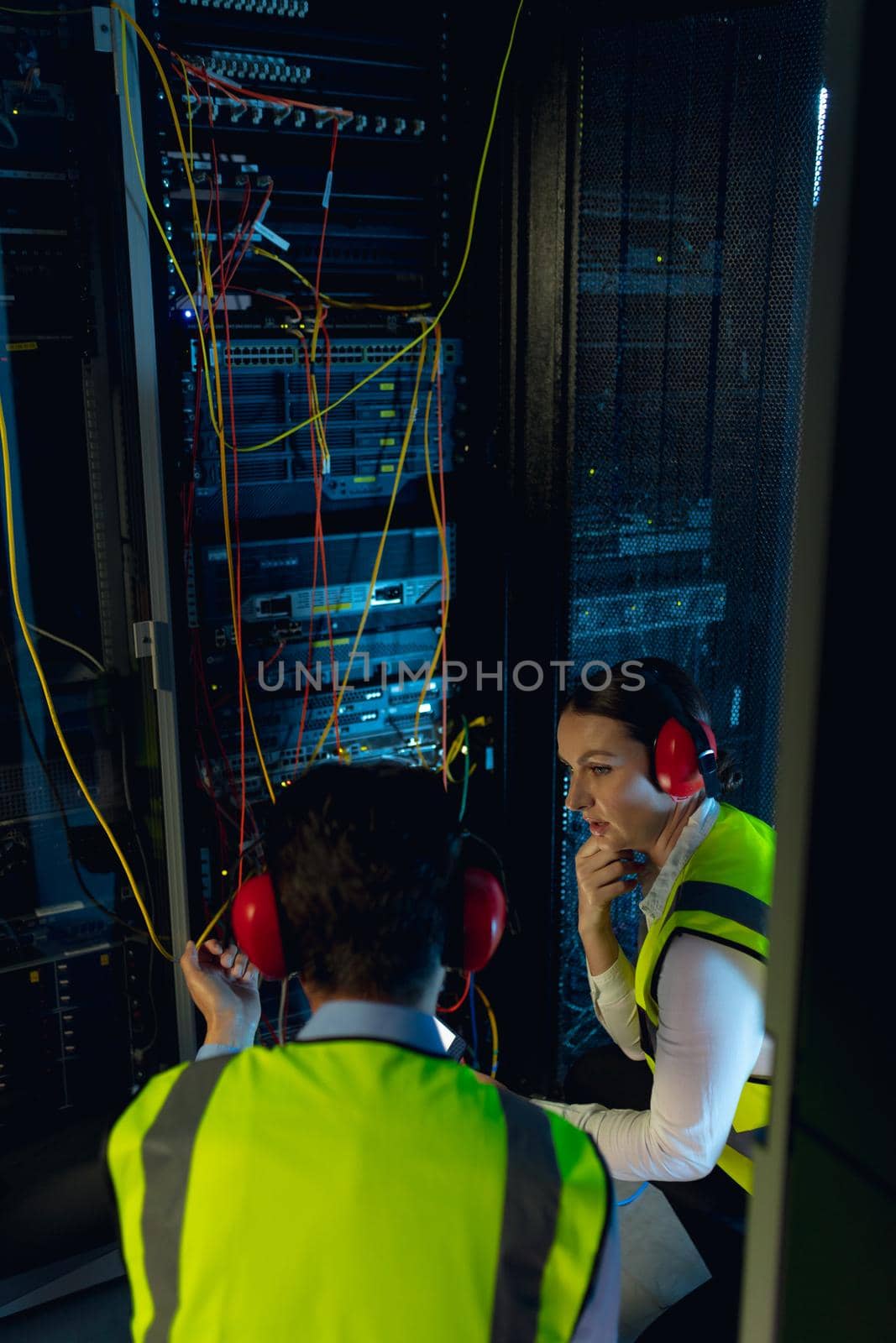 Diverse male and female engineers discussing together while inspecting iin computer server room by Wavebreakmedia