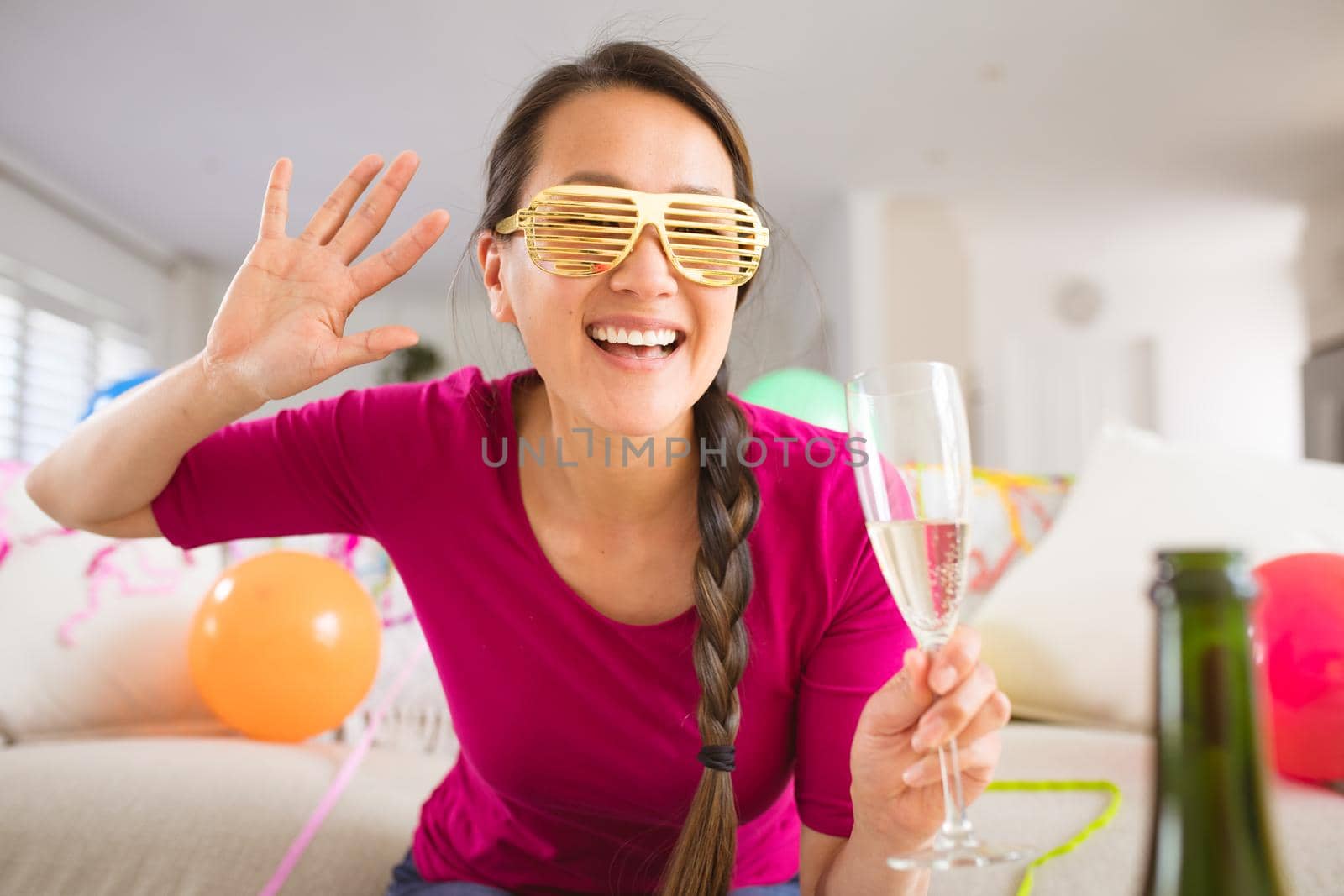 Happy asian woman raising champagne glass making new year's eve laptop video call by Wavebreakmedia