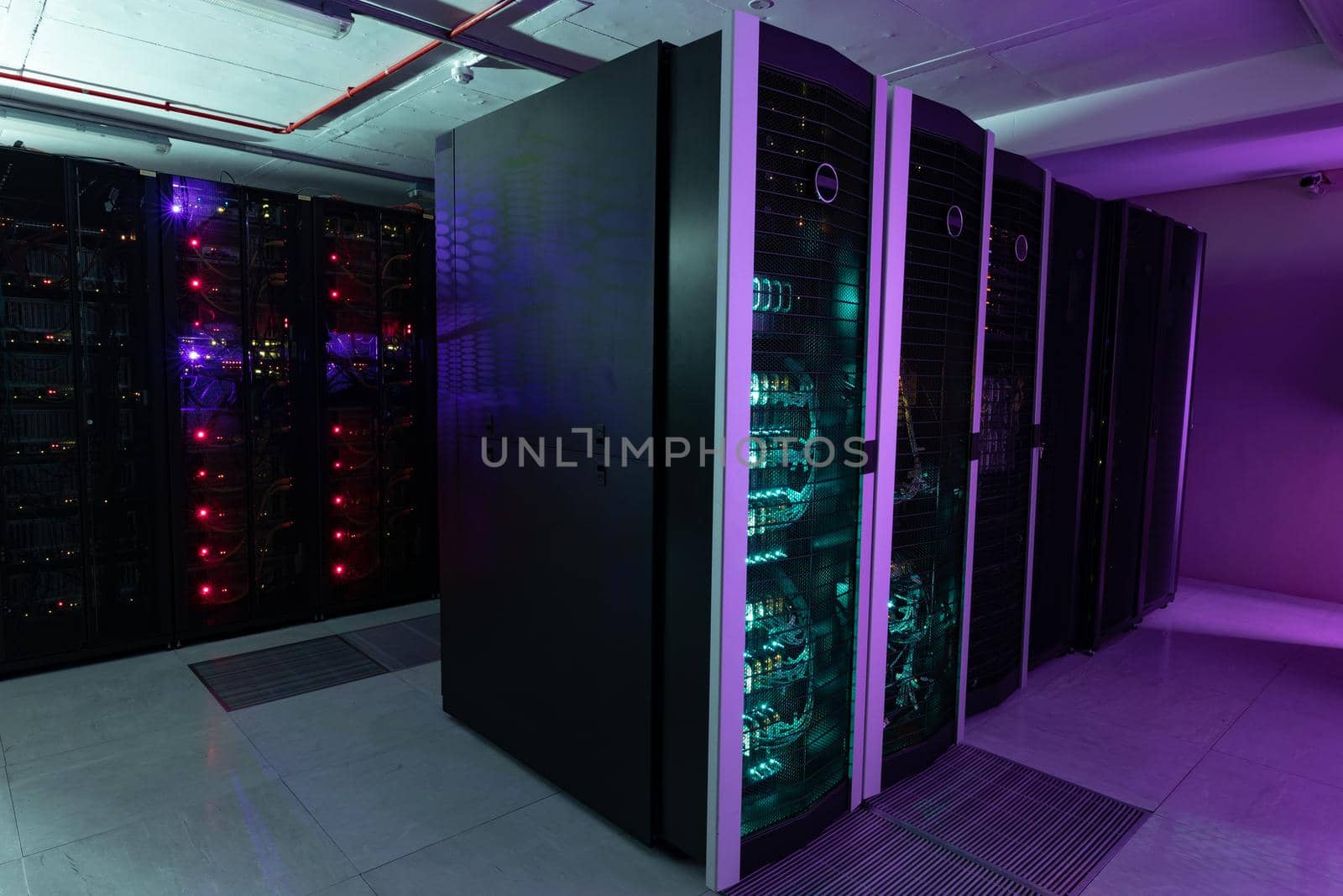 Data center with multiple rows of fully operational server racks. modern cloud computing technology concept.