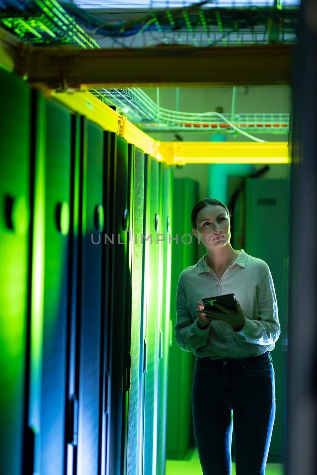 Caucasian female engineer using digital tablet while inspecting in computer server room by Wavebreakmedia