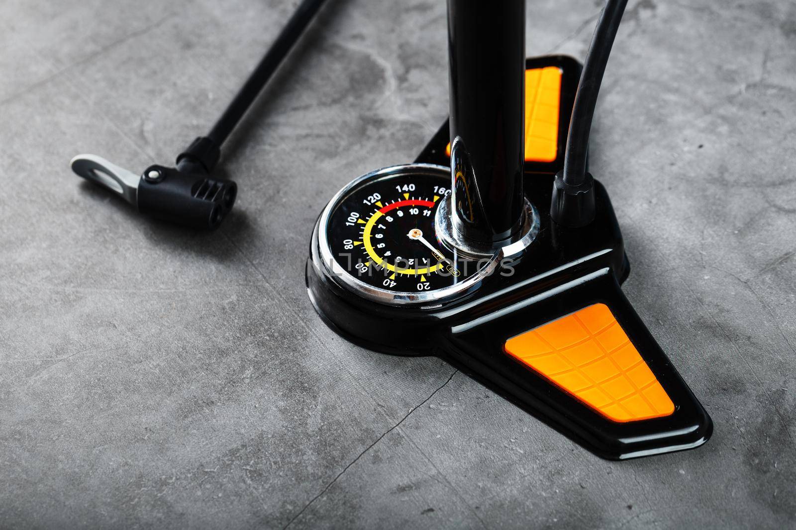 Air pump with a manometer and a wheel inflation hose on a dark background with free space