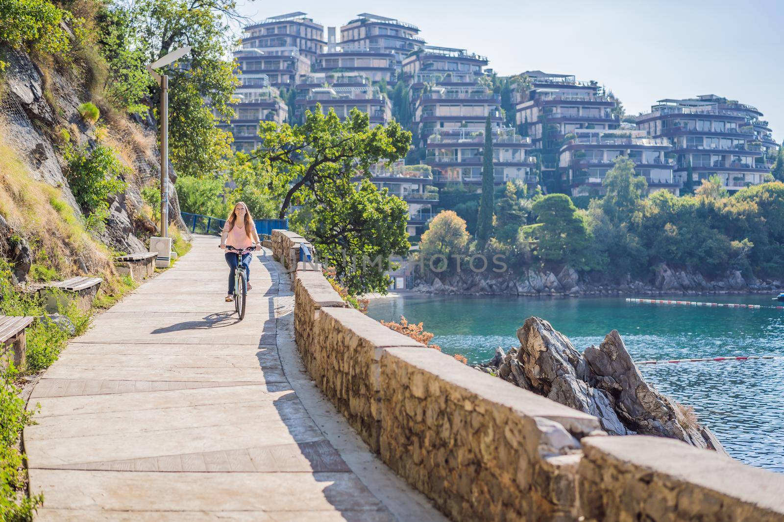 Woman tourist on a bicycle explores Budva in Montenegro. Cycling in Montenegro concept.