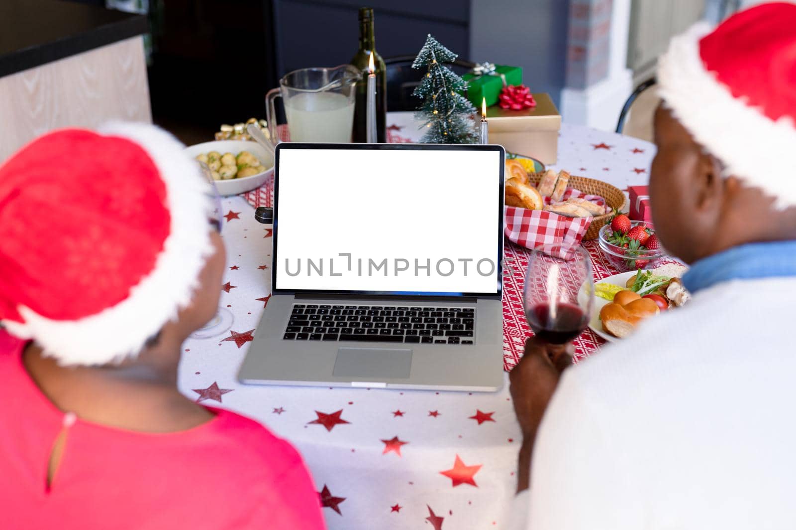 Back view of african american senior couple using laptop with copy space at christmas time by Wavebreakmedia