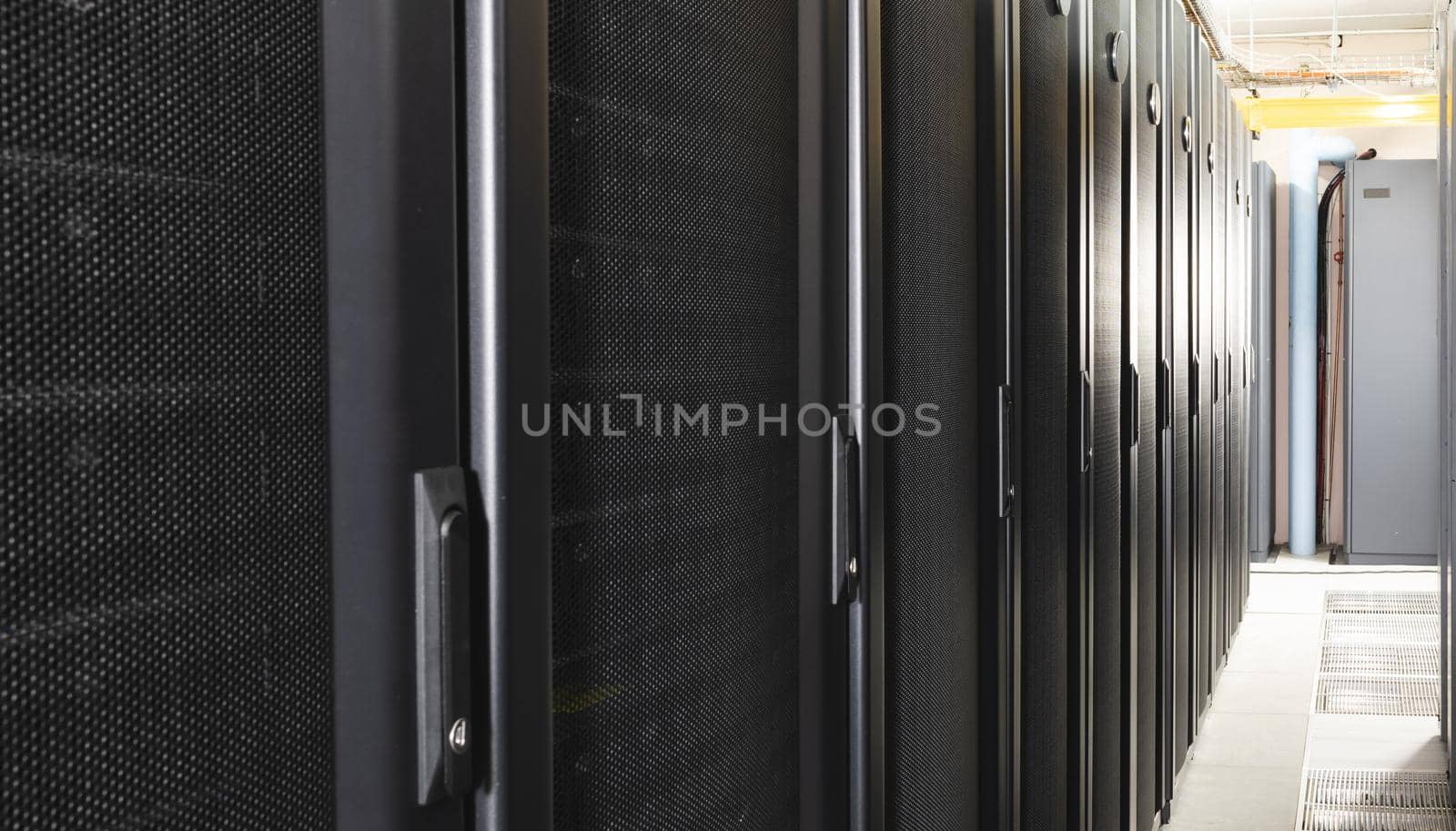 Data center with multiple rows of fully operational server racks. modern cloud computing technology concept.