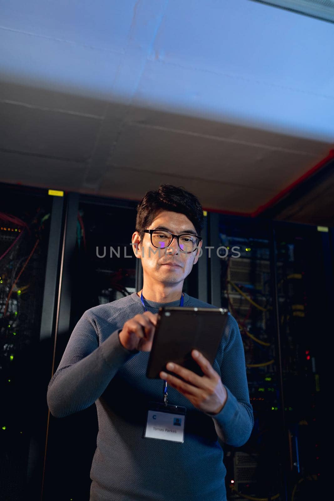 Asian male engineer using digital tablet in computer server room by Wavebreakmedia