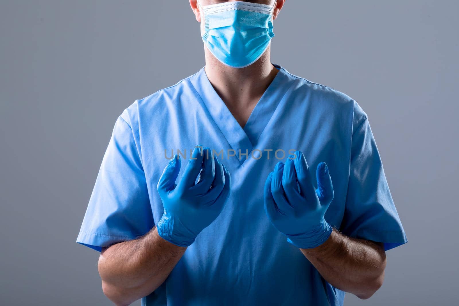 Caucasian male doctor wearing face mask and medical gloves. medical and healthcare technology concept during covid 19 coronavirus pandemic concept digitally generated composite.
