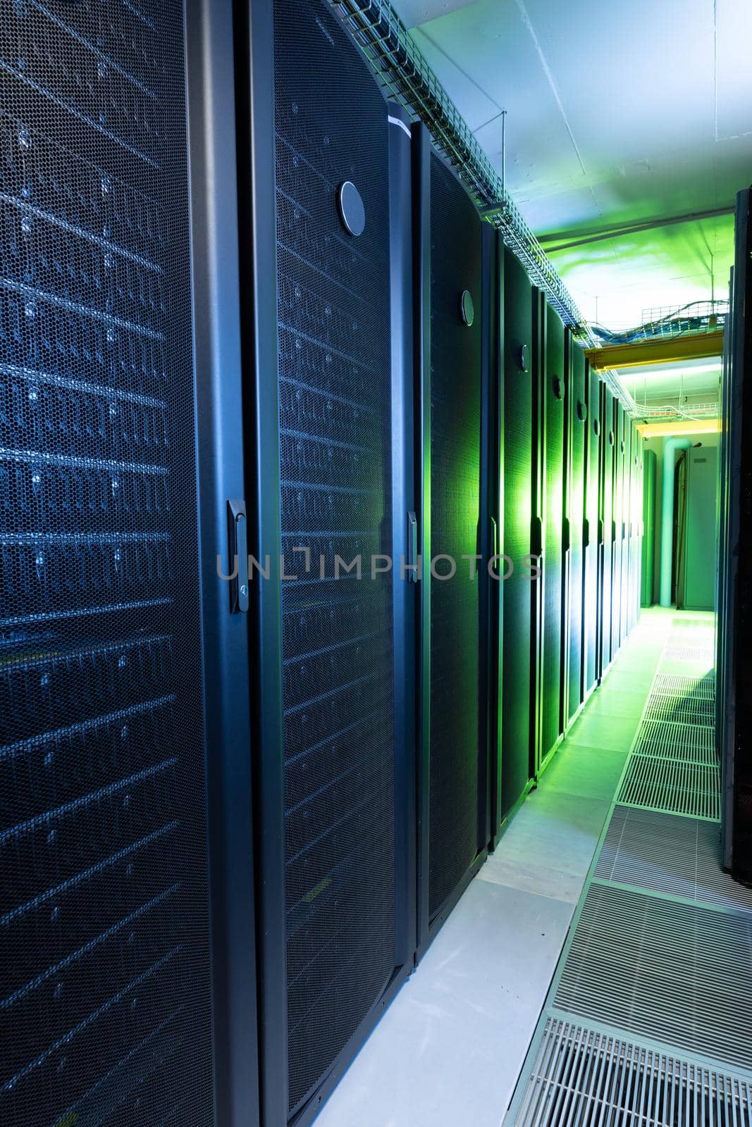 Data center with multiple rows of fully operational server racks. modern cloud computing technology concept.
