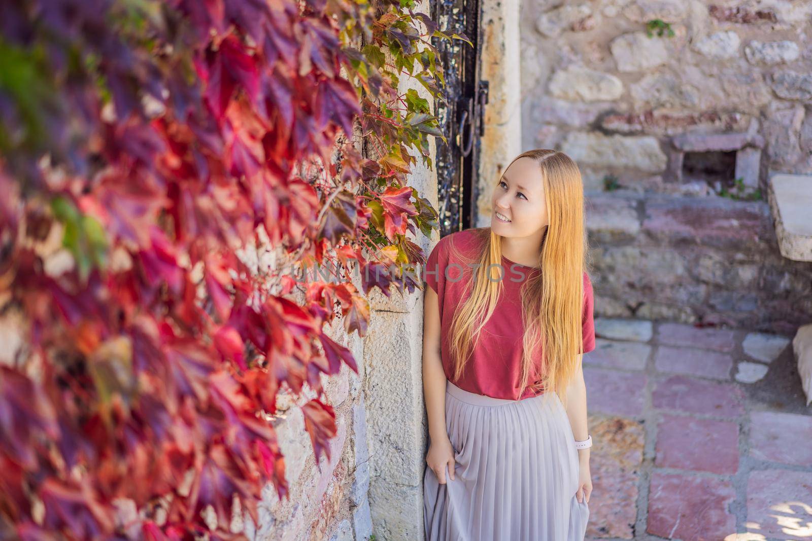 Woman tourist on background of beautiful view of the island of St. Stephen, Sveti Stefan on the Budva Riviera, Budva, Montenegro. Travel to Montenegro concept.