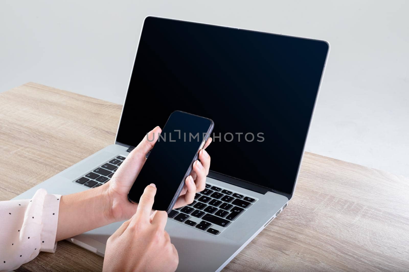 Midsection of caucasian businesswoman using laptop and smartphone, isolated on grey background. business, technology, communication and growth concept.