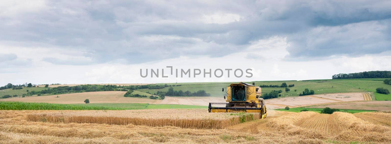 combine during harvest in french countryside landscape near charleville in french ardennes by ahavelaar