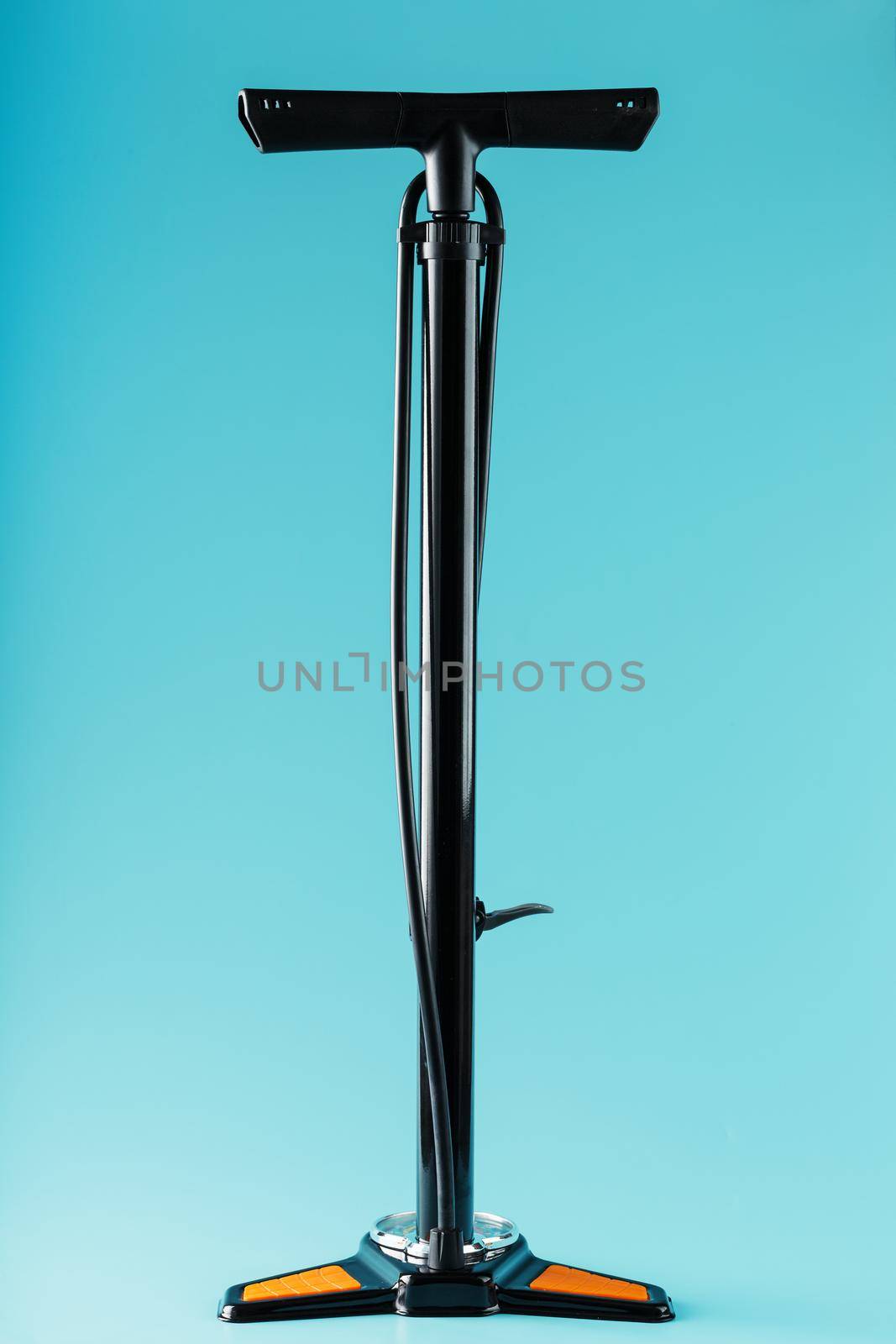 Black bicycle manual air pump for pumping wheels on a blue background with a vertical composition