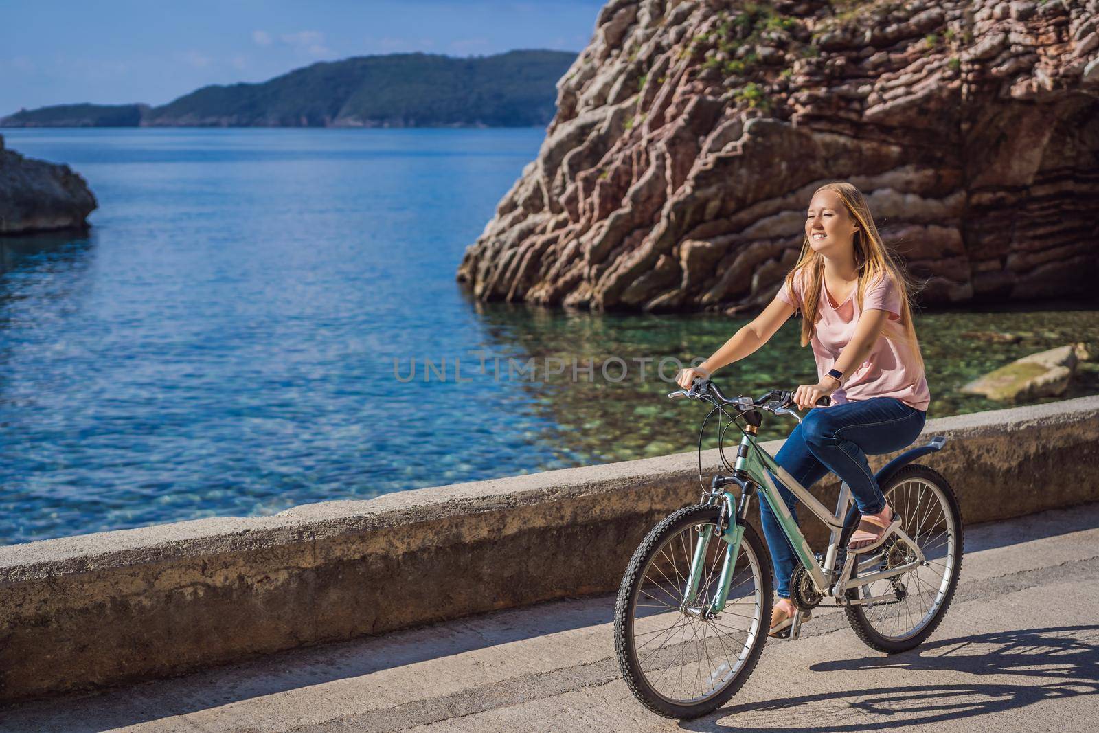 Woman tourist on a bicycle explores Budva in Montenegro. Cycling in Montenegro concept by galitskaya