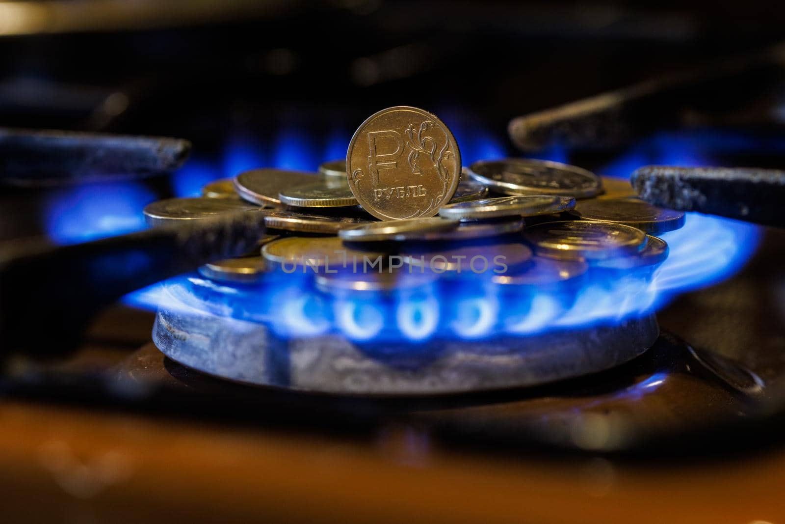 gas stove burner with russian ruble standing vertically on top, burning natural gas with blue flame, gas price in international fuel trade concept