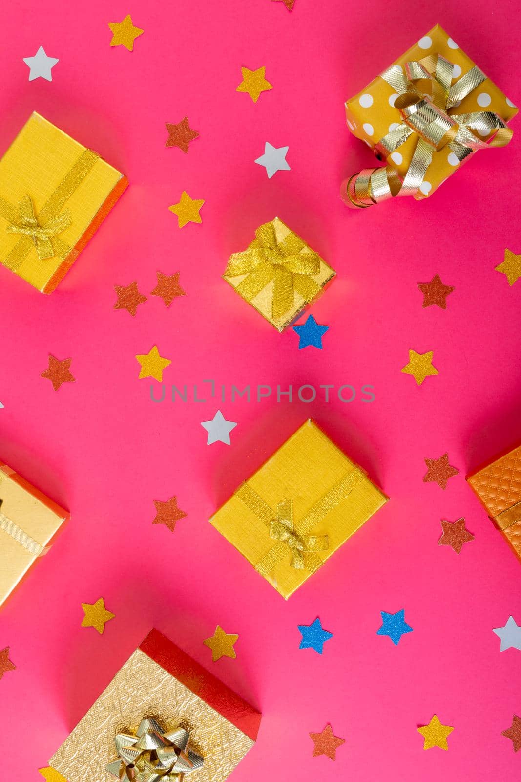 Composition of christmas decorations with presents and stars on pink background. christmas, tradition and celebration concept.