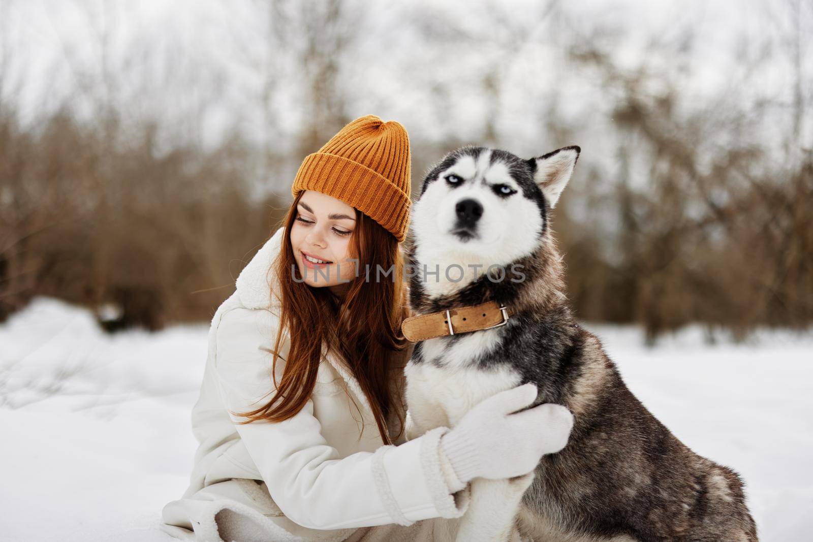 cheerful woman outdoors in a field in winter walking with a dog fresh air by SHOTPRIME