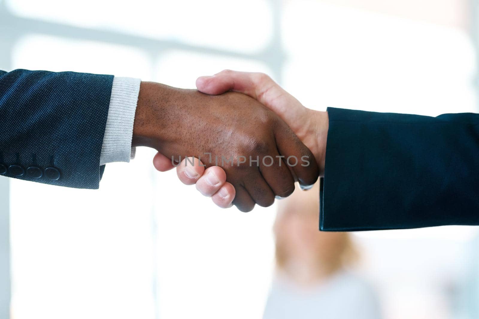 The deal is done. Closeup shot of two unrecognizable businessmen shaking hands in an office. by YuriArcurs