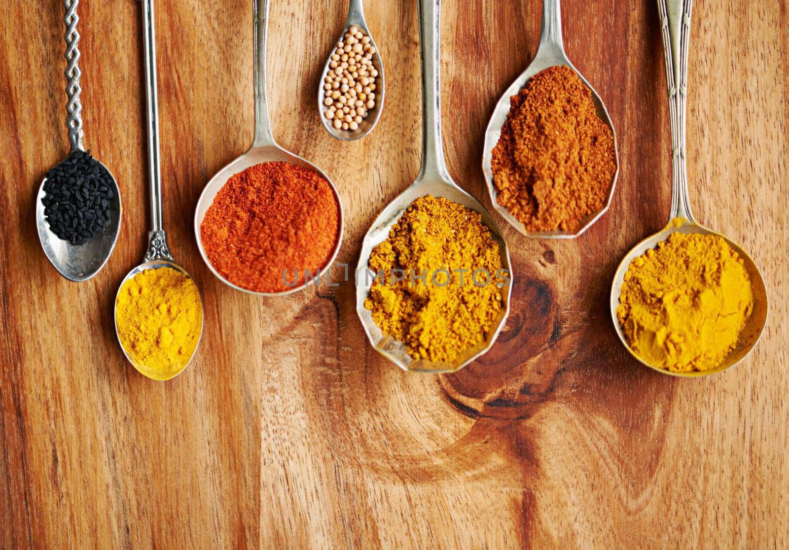 Cropped shot of spoons filled with a variety of spices.