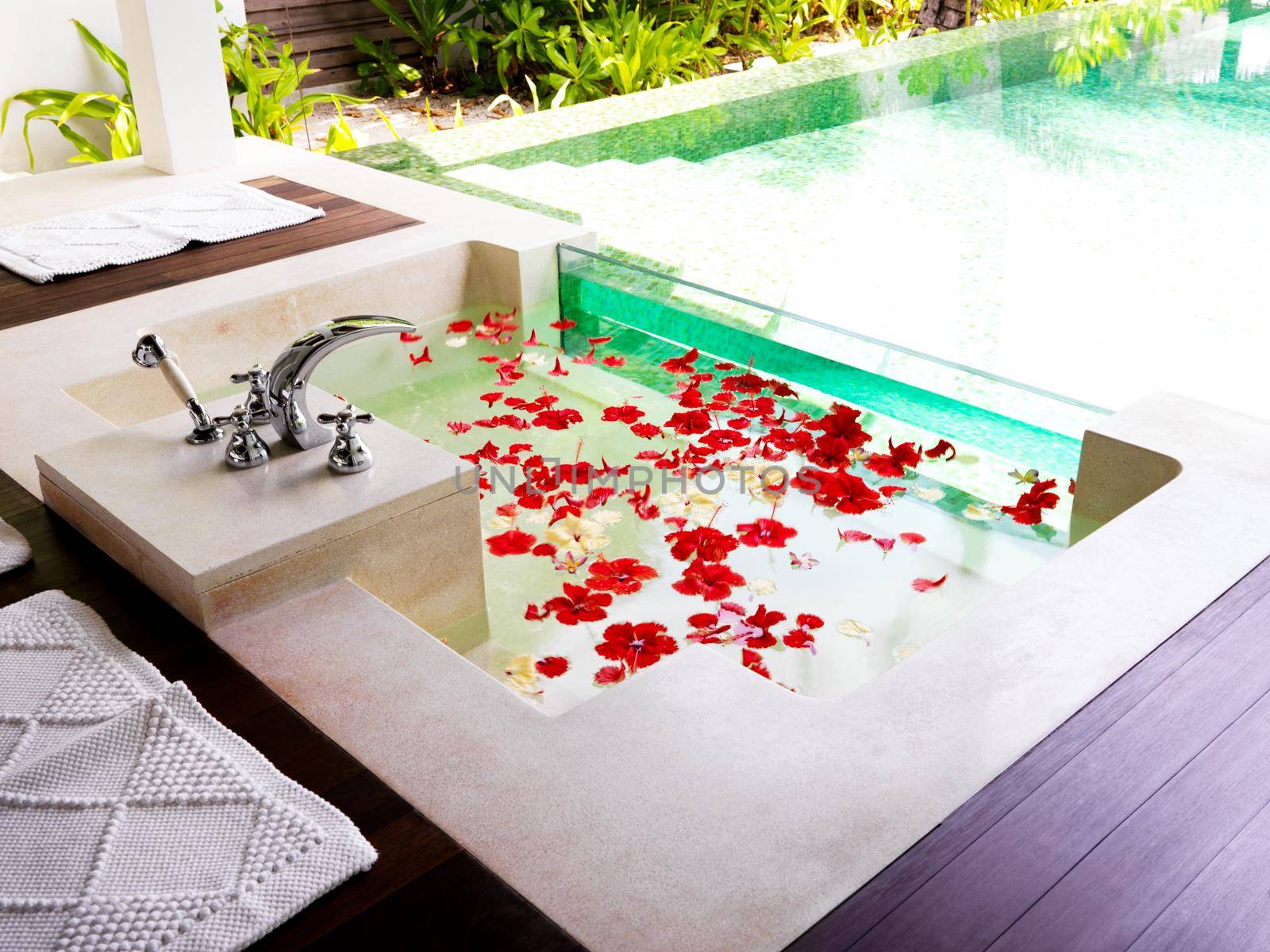 Modern bathroom with bath tub full of flower petals at a spa resort.
