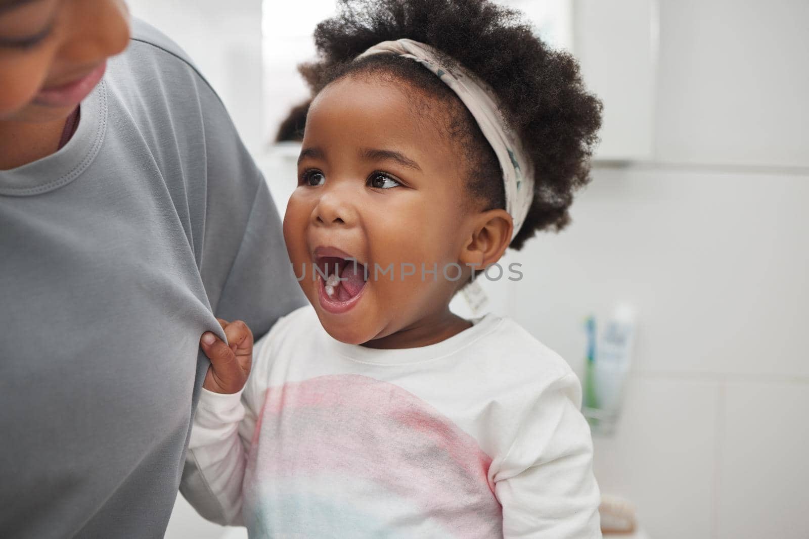 Shot of an adorable little girl opening her mouth to show her teeth to her mother in the bathroom at home.
