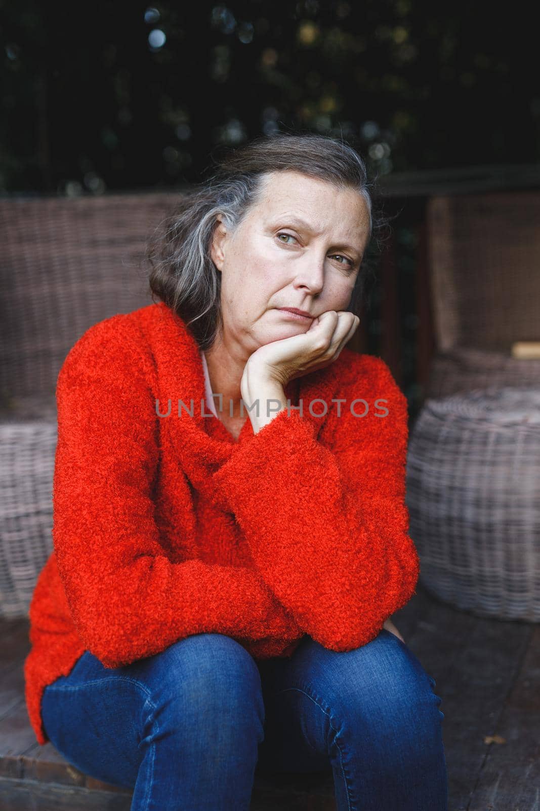 Thoughtful senior caucasian woman sitting and looking away in garden. retirement lifestyle, spending time alone at home.
