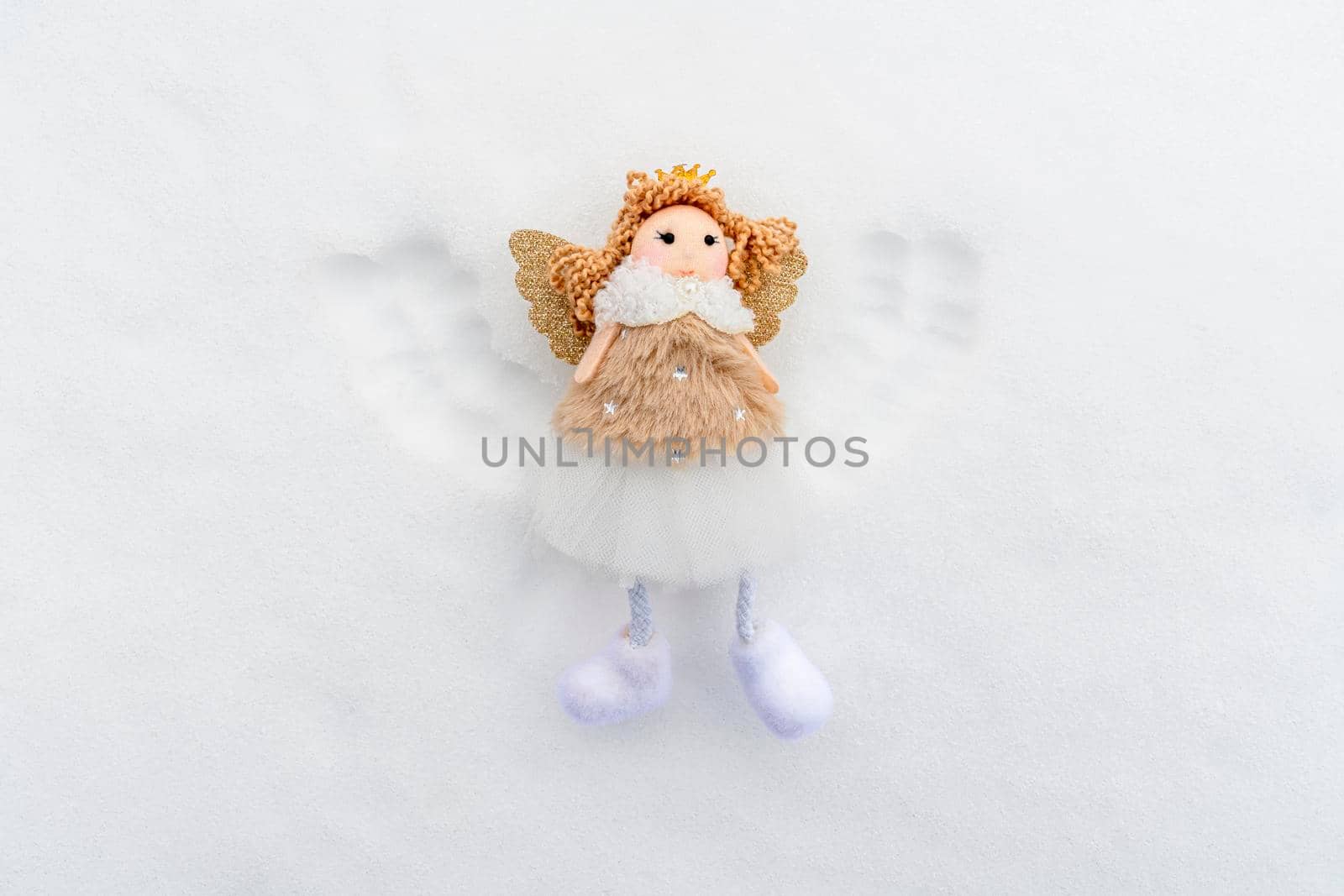 angel with wings in the snow top view by roman112007