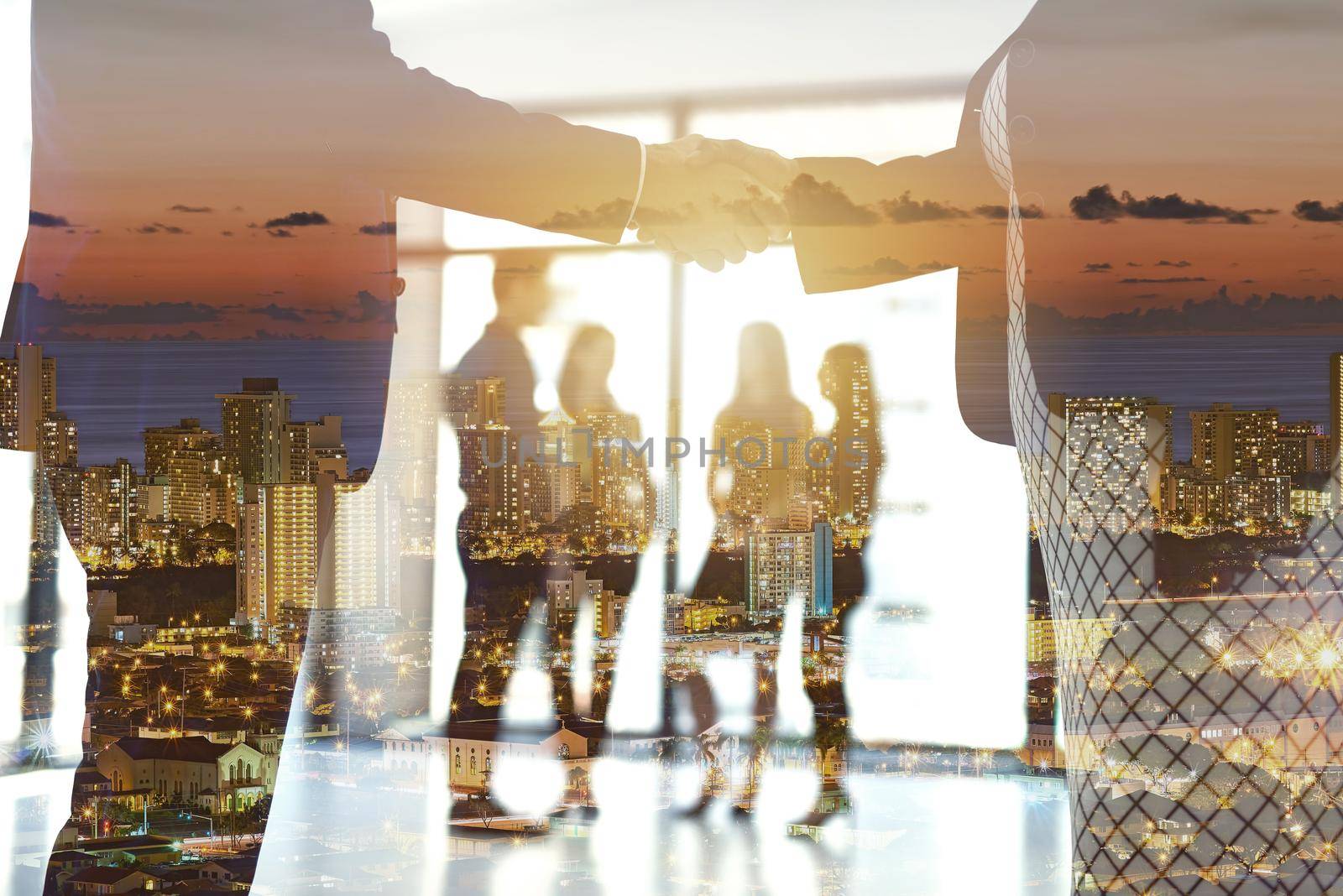 Shot of a city at sunset superimposed over businesspeople shaking hands in the boardroom.