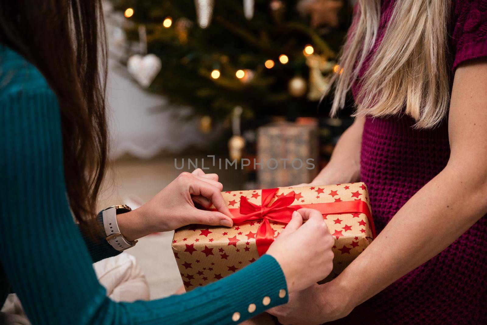 Preparing gifts together during Christmas in Poland. A woman's delicate hands.